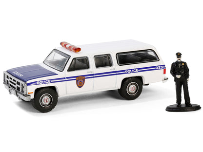 1985 GMC Suburban 2500 "New York City Transit Police Department" White with Blue Stripes and Police Officer Figure "The Hobby Shop" Series 16 1/64 Diecast Model Car by Greenlight-DiecastModeler.com